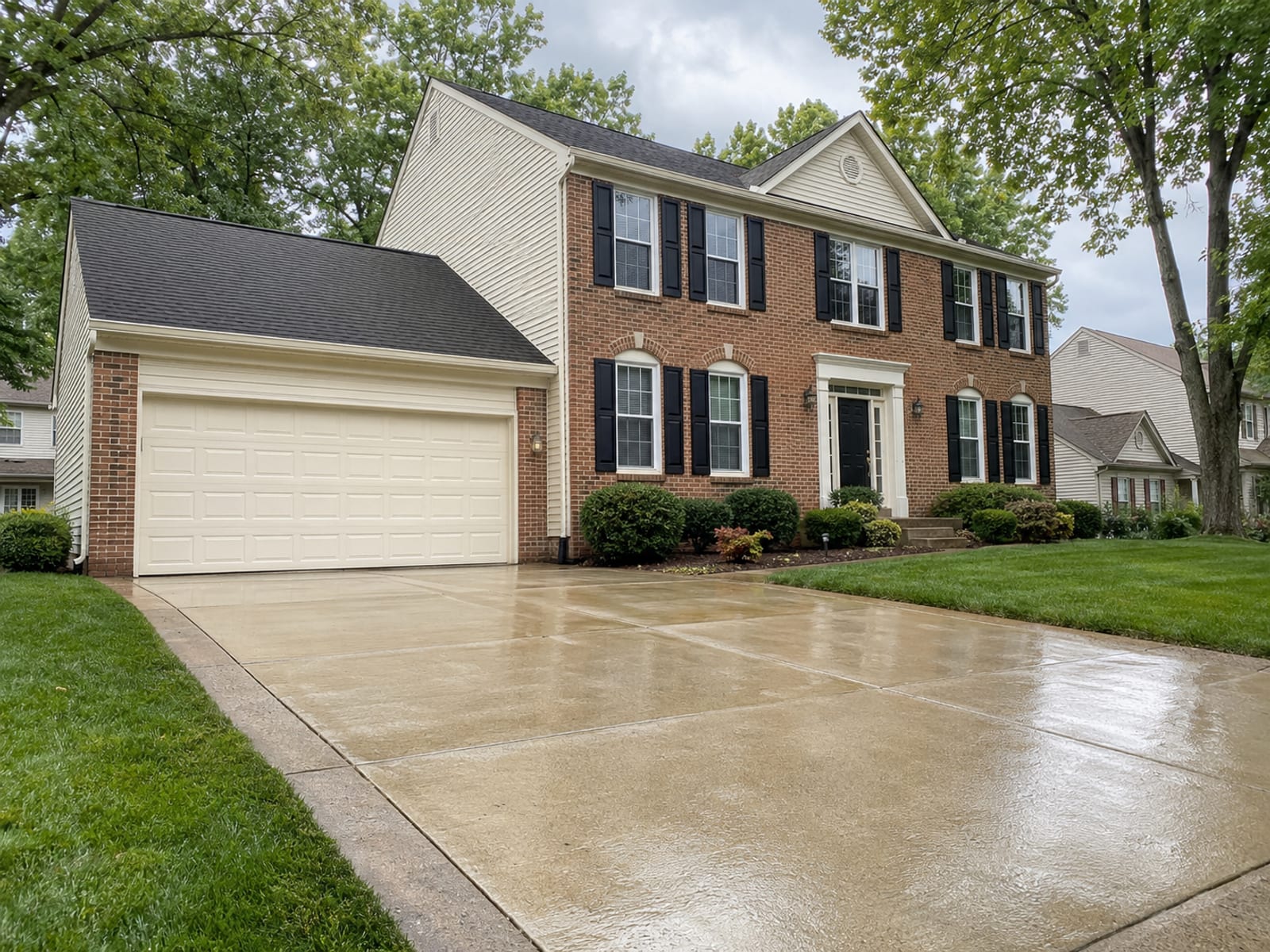 Freshly cleaned brick colonial home exterior with gleaming siding and driveway in a Baltimore County suburban neighborhood