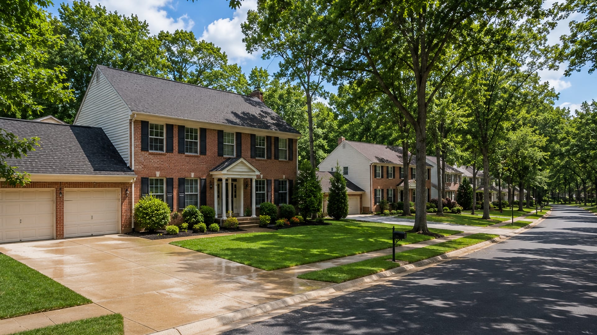 Wide aerial-perspective view of a clean mid-Atlantic brick colonial home on a tree-lined Baltimore County street after exterior washing